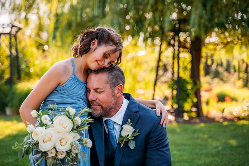daughter hugging groom at wedding 